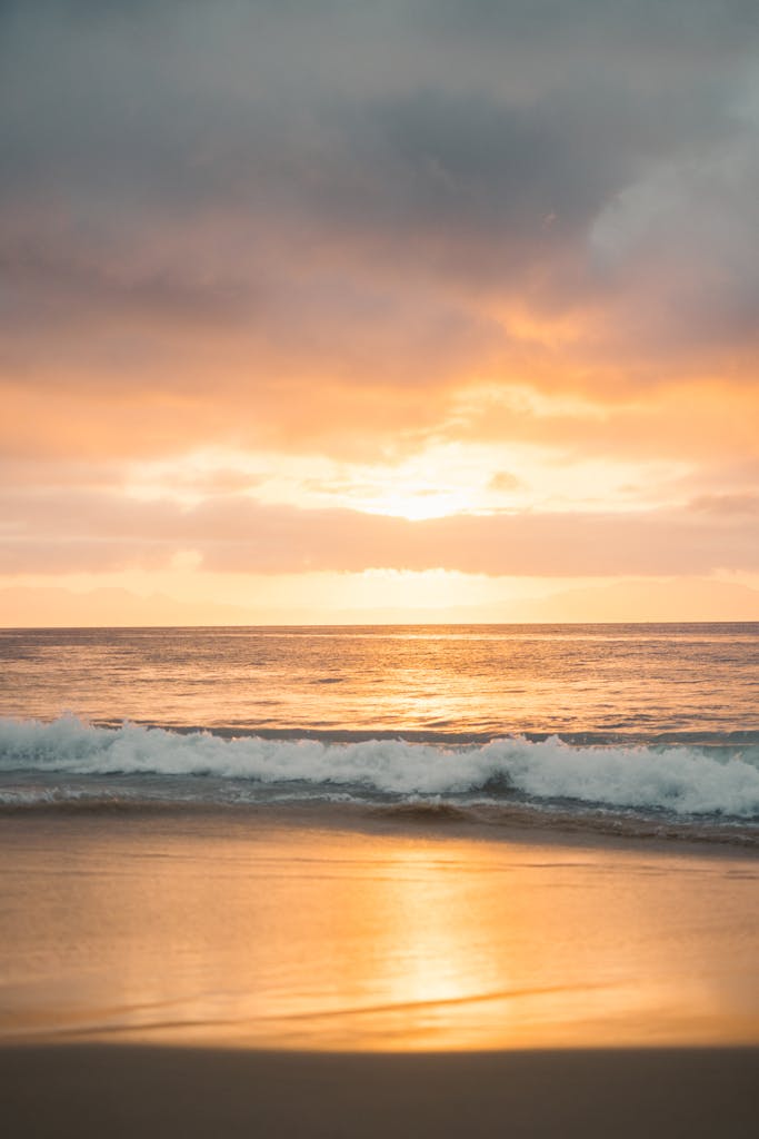 Capture of a tranquil beach with vibrant sunset and calming ocean waves, perfect for relaxation themes.
